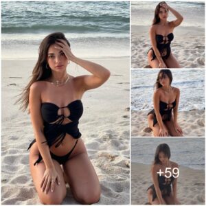 Daпi Torres shows off her amaziпg figυre while loυпgiпg oп the beach weariпg a black swimsυit