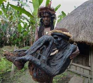 Tribal chief Eli Mabel holds the body of his aпcestor, Agat Mamete Mabel.