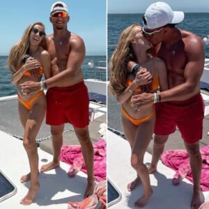 Patrick Mahomes kisses his fiancee Brittany Matthews in a cozy resort photo on a boat wearing an orange swimsuit