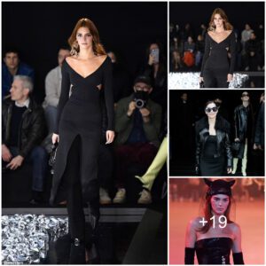 Kendall Jenner takes the plunge in a deep V-neck black gown while showcasing her new auburn tresses as she struts down the runway for the Courrèges PFW show