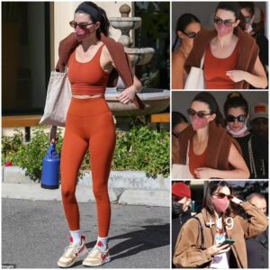 Kendall Jenner plays up endless legs in high-waisted khaki slacks and high-heeled boots after flashing taut midriff in orange workout gear