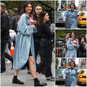 Kendall Jenner looks typically chic in a light blue trench coat and flashes her legs while posing confidently as she films new campaign in NYC