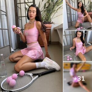 Dua Lipa gets into the Wimbledon spirit in a pink tank top and matching tennis skirt as she poses with a racket and balls