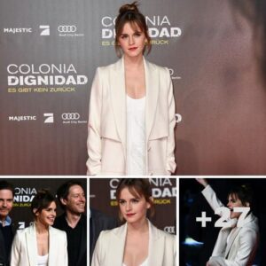 Emma Watson cuts a classy figure in a plunging white mini-dress and a stylish cream overcoat for Colonia première