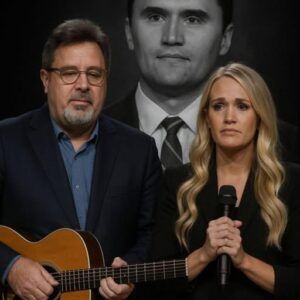Vince Gill and Carrie Underwood walked side by side to center stage. Vince clutched his guitar to his chest, while Carrie held the microphone with trembling hands. The crowd, moments earlier jittery, jiji